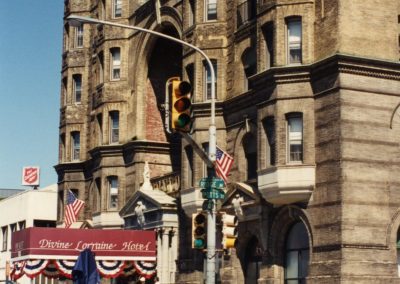 88-historic_74-color-right-angle-exterior-photo-of-enterance-partial-building-street-with-street-signs-min
