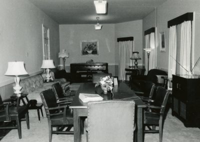 99-historic_85-b_w-photo-of-meeting-room-with-table-chairs-sofa-piano-min